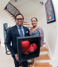 Dr. Monroe Harris and his wife, Dr. Jill Bussey, show boxing gloves autographed by the champ, who grew up in the same neighborhood with them in Louisville, Ky.
