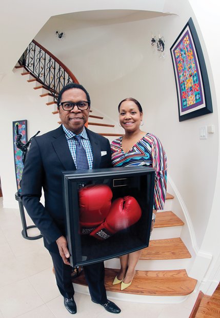 Dr. Monroe Harris and his wife, Dr. Jill Bussey, show boxing gloves autographed by the champ, who grew up in the same neighborhood with them in Louisville, Ky.