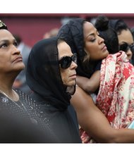 Muhammad Ali’s family takes part in the traditional Muslim service last Thursday at Louisville’s Freedom Hall for The Champ. They are, from left, Khalilah Ali, Mr. Ali’s second wife; Lonnie Ali, his wife of the last 30 years; and daughter Laila Ali.
