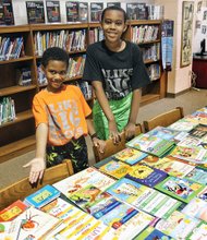 Brothers Jace, 7, left, and Jazz Miles, 10, show off some of the 1,400 books they collected to give to their fellow students at Richmond’s Linwood Holton Elementary School. The boys’ efforts mean that Holton’s 600 students will have at least two books of their own to read during summer break.
