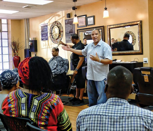 
Barbershop talk
Richmond Police Chief Alfred Durham tries a new outreach tactic — meeting people informally in a barbershop to hear their concerns. Minus his familiar uniform, he held the session last Saturday at the Celebrity Barber Lounge, 406 N. 1st St. in Jackson Ward. About 20 people turned out. Behind him, owner John R. Dean, who gave the chief the idea, puts the finishing touches on a customer’s cut.  