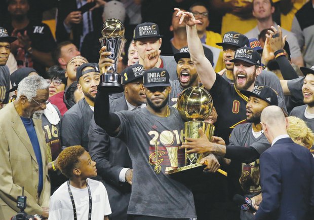 LeBron James, center, celebrates on the court with teammates following the Cleveland Cavaliers’ NBA championship victory Sunday over the Golden State Warriors in Oakland, Calif. 
