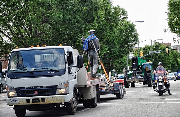 Cityscape // A motorcycle officer escorts the truck carrying the statue down Grace Street en route to Byrd Park.