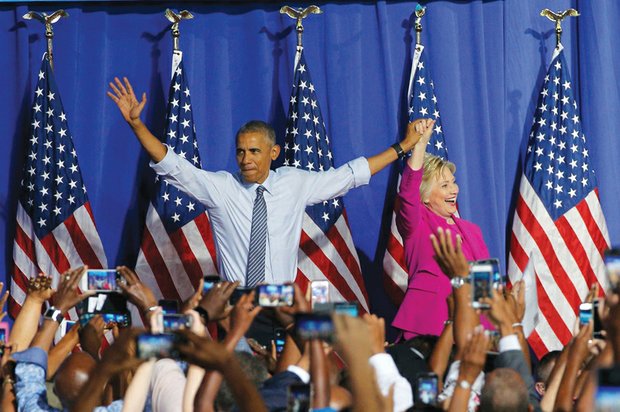 President Barack Obama waves with Hillary Clinton, the presumptive Democratic presidential nominee, at a campaign event Tuesday in Charlotte, N.C. Neither the president or Mrs. Clinton were told ahead of time about the FBI announcement or conclusion.