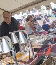 Herman Baskerville, owner of Big Herm’s Kitchen, oversees operations at his food tent last year at the Washington NFL training camp on West Leigh Street. Mr. Baskerville is one of the minority-owned vendors selected this year to return to the camp that opens July 28.
