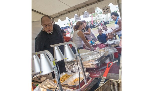 Herman Baskerville, owner of Big Herm’s Kitchen, oversees operations at his food tent last year at the Washington NFL training camp on West Leigh Street. Mr. Baskerville is one of the minority-owned vendors selected this year to return to the camp that opens July 28.
