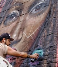 Victor “Marka27” Quiñonez adds finishing touches to his new “Givers of the Divine” mural. Location: 6 W. Cary St. in Downtown. From Brooklyn, N.Y., Mr. Quiñonez is among a dozen visiting artists who painted more than 14 murals on buildings during this summer’s Richmond Mural Project, which ended last week.