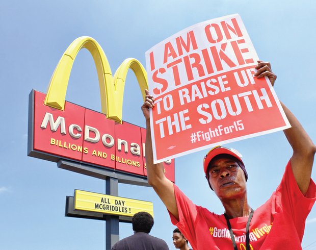 Walkout for living wage // Rolanda McMillan protests pay and working conditions in front of the McDonald’s restaurant at 2011 Chamberlayne Ave. She was among 28 workers at the restaurant who picketed last Thursday for basic safety equipment such as oven mitts and to protest cuts to work schedules. 