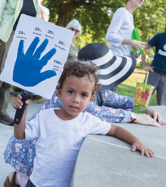 One of God’s children //
Gabriel Denison, 2, holds a sign offering details of his ethnic background during last Friday’s Three Parks Walk for Peace in the East End. The youngster attended the march with his parents, Liz and Rob Denison, and year-old sister, Cora, as people gathered with messages of hope and unity despite the recent violence in U.S. communities and abroad. Please see story, more photos, B2.