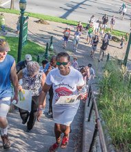 A string of walkers climb the stairs to Jefferson Park, the final stop on the Three Parks Walk for Peace last Friday sponsored by the Neighborhood Resource Center, Central Montessori School and other community groups.