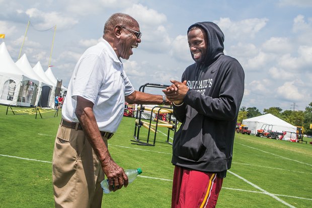 NFL cornerback Greg Toler, right, is reunited with Coach Willard Bailey Monday at the Washington team’s training camp in Richmond. Coach Bailey gave Toler his start in college ball at St. Paul’s College in Lawrenceville.