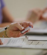 
A North Carolina election worker checks a voter’s ID during the March presidential primary election. However, such ID checks may not be needed in the upcoming Nov. 8 election. A new ruling from the 4th U.S. Circuit Court of Appeals, based in Richmond, struck down the state’s ID rules and other voting restrictions as a targeted effort to keep African-Americans from voting.