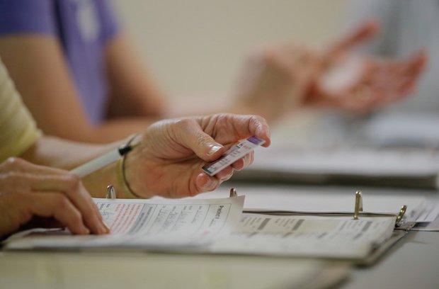 
A North Carolina election worker checks a voter’s ID during the March presidential primary election. However, such ID checks may not be needed in the upcoming Nov. 8 election. A new ruling from the 4th U.S. Circuit Court of Appeals, based in Richmond, struck down the state’s ID rules and other voting restrictions as a targeted effort to keep African-Americans from voting.