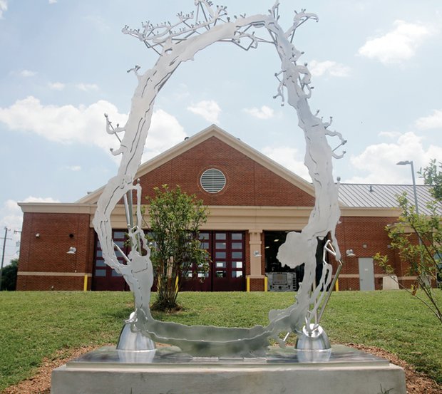 Cityscape // This new public sculpture, titled “Estuary,” now stands behind Fire Station No. 17 at 2211 Semmes Ave.  Richmond Mayor Dwight C. Jones led the July 21 unveiling of the 10-foot-tall, stainless steel piece. The sculptor is Ross Caudill of Brooklyn, N.Y., who earned his master’s in fine arts at Virginia Commonwealth University. When the station was built in 2012, 1 percent of the $4.6 million construction cost was set aside to pay for public art to go with it. Mr. Caudill was paid $34,103, and another $5,000 was spent to install his work. However, his sculpture is largely invisible to people and traffic passing the station on Semmes. It is actually located outside the station property in adjacent Canoe Run Park, where it overlooks people playing and exercising. The city park is at 20th Street and Riverside Drive. 