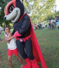 Semaj Cooper, 8, enjoys a two-step with Nutzy, the Richmond Flying Squirrels mascot. This gathering in Pollard Park at Chamberlayne Avenue and Brookland Park Boulevard, sponsored by Neighborhood Housing Services of Richmond, was one of many in the Richmond area and across the nation to strengthen bonds between residents and law enforcement officers. The 33rd annual national family and neighborhood event also aims to heighten awareness of crime and drug prevention.