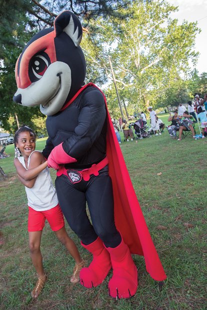 Semaj Cooper, 8, enjoys a two-step with Nutzy, the Richmond Flying Squirrels mascot. This gathering in Pollard Park at Chamberlayne Avenue and Brookland Park Boulevard, sponsored by Neighborhood Housing Services of Richmond, was one of many in the Richmond area and across the nation to strengthen bonds between residents and law enforcement officers. The 33rd annual national family and neighborhood event also aims to heighten awareness of crime and drug prevention.