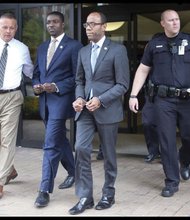 
NAACP President Cornell W. Brooks, right, and Stephen Green, national director of the NAACP Youth and College Division, are led in handcuffs Monday from the Roanoke office of Congressman Bob Goodlatte after a six-hour sit-in on voting rights issues. 