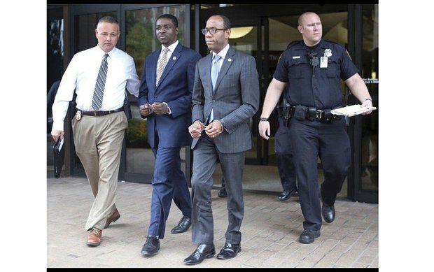 
NAACP President Cornell W. Brooks, right, and Stephen Green, national director of the NAACP Youth and College Division, are led in handcuffs Monday from the Roanoke office of Congressman Bob Goodlatte after a six-hour sit-in on voting rights issues. 