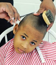 Dapper for School // Jayden Morgan wants to look his best when he starts kindergarten at J.E.B. Stuart Elementary School in Richmond. He got his hair cut last Saturday by Jamaal Umar Abdur-Rahman during the 8th Annual Back-to- School Rally at Martin Luther King Jr. Middle School in the East End. Students also received backpacks and school supplies at the event hosted by Richmond School Board member Shonda Harris-Muhammed. Games, music, food and other activities pumped up the back-to-school spirit.