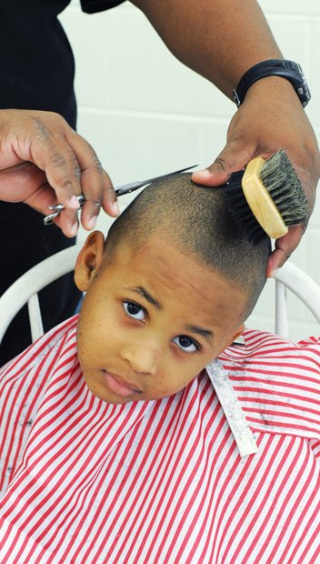 Dapper for School // Jayden Morgan wants to look his best when he starts kindergarten at J.E.B. Stuart Elementary School in Richmond. He got his hair cut last Saturday by Jamaal Umar Abdur-Rahman during the 8th Annual Back-to- School Rally at Martin Luther King Jr. Middle School in the East End. Students also received backpacks and school supplies at the event hosted by Richmond School Board member Shonda Harris-Muhammed. Games, music, food and other activities pumped up the back-to-school spirit.