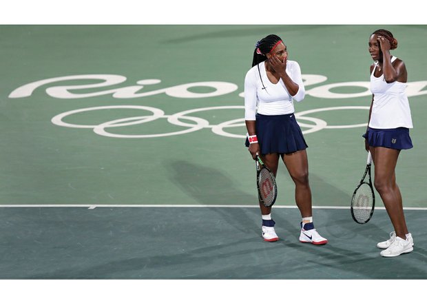 Venus Williams, right, confers with her sister, Serena, after losing a point in the first round doubles match Sunday against Lucie Safarova and Barbora Strycova of the Czech Republic at the Summer Olympics in Brazil.