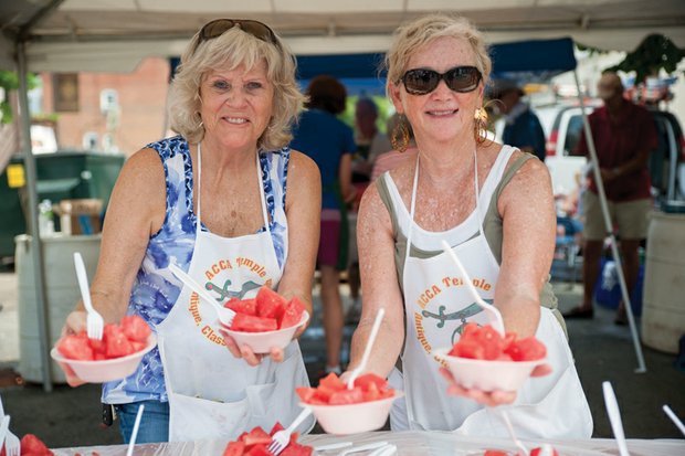 Fruity fun in Carytown // With the weekend temperatures soaring, thou- sands of people enjoyed a cool summer favorite — watermelon — at Sunday’s 33rd Annual Carytown Watermelon Festival.
Several blocks of West Cary Street were trans- formed into a large street party filled with the sounds of bands, entertainers and food.
Right, Connie Chisholm, left, and Pat McKenzie with the ACCA Temple Shriners serve bowls of the refreshing fruit.
Proceeds from the watermelon sales benefit the Shriners Hospitals for Children, which provides care for youngsters without charge. Organizers said several Richmond area children are being helped at the hospitals, the closest of which is located in Greenville, S.C.