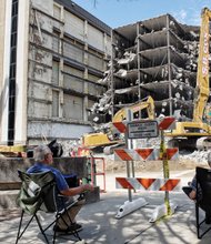 Spectators have a ringside seat last Sunday as workers use powerful machines to de- molish the parking deck of the vacant Richmond Plaza building at 7th and Cary streets in Downtown. Clearing the parking deck and building is the first step toward building the planned 20-story office space for Dominion Resources. Demolition is expected to take four months, including creating room for four levels of underground parking. The next phase of two years involves construction of a 413-foot-tall facility that is expected to cost more than $100 million to build and outfit. The new building’s opening is planned for early 2019.