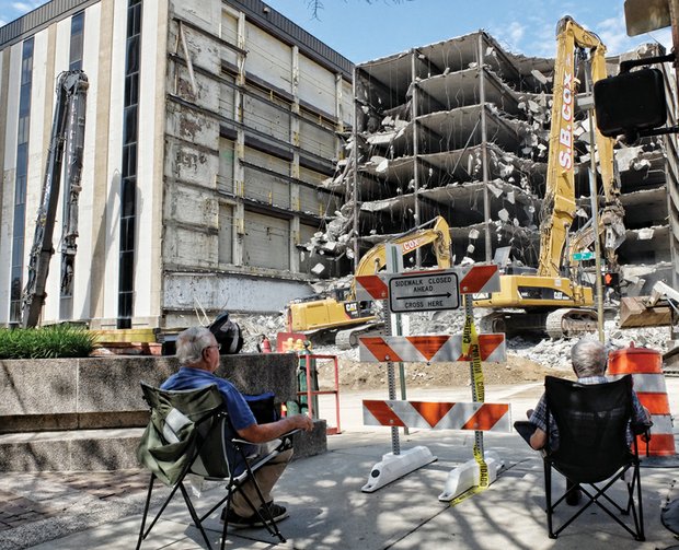 Spectators have a ringside seat last Sunday as workers use powerful machines to de- molish the parking deck of the vacant Richmond Plaza building at 7th and Cary streets in Downtown. Clearing the parking deck and building is the first step toward building the planned 20-story office space for Dominion Resources. Demolition is expected to take four months, including creating room for four levels of underground parking. The next phase of two years involves construction of a 413-foot-tall facility that is expected to cost more than $100 million to build and outfit. The new building’s opening is planned for early 2019.