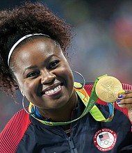 Michelle Carter shows off her gold medal won in the shot put competition.