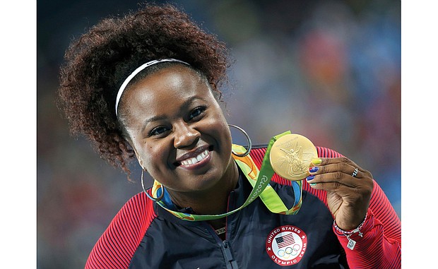 Michelle Carter shows off her gold medal won in the shot put competition.