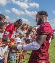 Big thanks for big fans //Willie Jefferson, right, hands an autographed mini football to another fan.
The event featured musical performances and dance competitions before the team’s practice. After practice, team members mingled with the crowd.