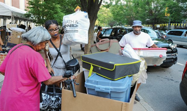 Freshman Selina Sykes of Baltimore, center, receives a helping hand from her grandmother, Albertha Sykes, and her dad, Lee Sykes, as she moves into Virginia Commonwealth University’s Johnson Hall last Saturday. Parents, relatives and friends formed the line of movers at the West Franklin Street residence hall. 