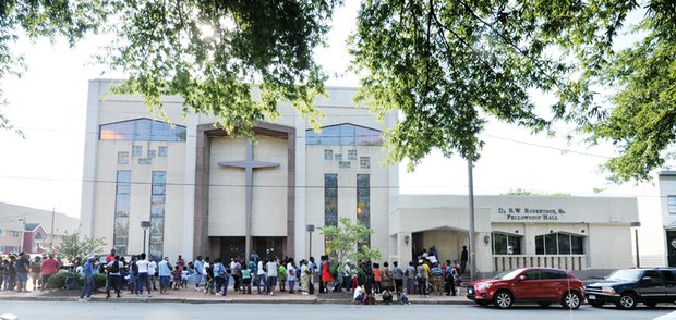 New kicks for kids // Dozens of people line the sidewalk last Saturday for the 4th Annual Back to School Shoe Drive at Cedar Street Baptist Church of God in Church Hill. The church
gave away hundreds of pairs of new shoes to youngsters who will be returning to classrooms on Tuesday, Sept. 6. 