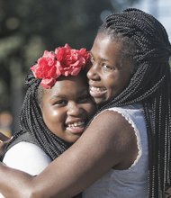 Sixth-grader Ayanna Street, left, and her mother, Yakysha Langhorne, embrace during a first-day-of-school pep talk
while waiting at the bus stop Tuesday at Westover Hills Elementary School. The South Side elementary school is
Ayanna’s hub to get to Binford Middle School in the West End under the new transportation plan.