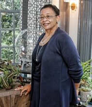 Viola O. Baskerville, the former state secretary of administration, poses in the study of her Ginter Park home, Pineapple Acre, which was selected as this year’s Richmond Symphony Orchestra League Designer House. 