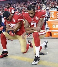 San Francisco 49ers safety Eric Reid, left, and quarterback Colin Kaepernick kneel during the national anthem during the opening of the NFL team’s game Monday night against the Los Angeles Rams.