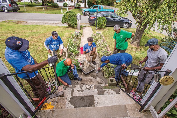 Below, volunteers, from left, Randy
Thomas, James Nelson, Harold Hockaday, Derrick Isler,
Richard Burwell, Judith Wansley and Charlie Booker work
to repair the steps and walkway outside the Highland
Springs home of an elderly person.