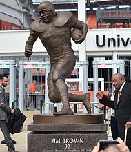 Football icon Jim Brown, right, strikes a pose with the statue of himself that now stands outside the stadium of his former team, the Cleveland Browns. The statue of the pro football hall of famer who ranks among the all-time great running backs was unveiled Sept. 18.