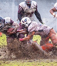 Virginia Union University junior Kevin Green carries the ball through the mud bowl during the Panthers’ homecoming game last Saturday at Hovey Field. The Panthers beat the Lincoln University Lions 39-6.