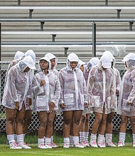 The Virginia Union University Rah Rahs huddle to stay warm and dry between cheers at Saturday’s football game at Hovey Field.
