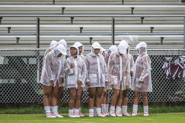 The Virginia Union University Rah Rahs huddle to stay warm and dry between cheers at Saturday’s football game at Hovey Field.
