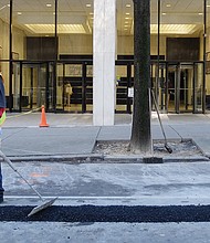 A worker smooths fresh asphalt filling a trench in the street created for installation of a utility line. Location: 800 block of East Main Street in Downtown. Dozens of repair and street projects are underway across the city, creating detours and other temporary disruptions for motorists. 