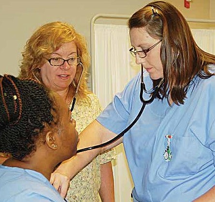 Carol Decker, a CAN adjunct instructor for South Suburban College's Basic Nurse Assistant Training Program (BNATP) looks on as two students perform a blood pressure check. The college will host its BNATP open house, October 31st from 4 pm - 5:30 pm. Photo Credit: JoAnn Mabry