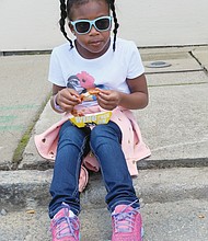 
Malai Keys, 7, sits down to savor the flavor of her wings at the 17th Street Farmers’ Market.