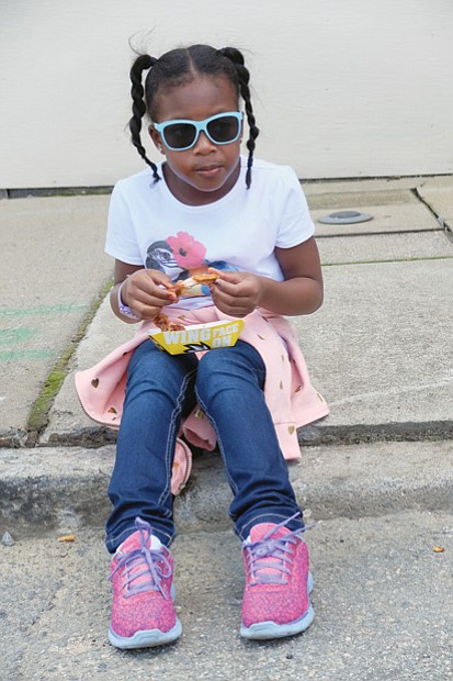 
Malai Keys, 7, sits down to savor the flavor of her wings at the 17th Street Farmers’ Market.