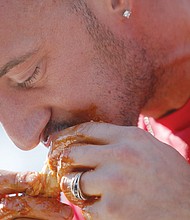 Mike Longo digs into a saucy wing at the WingFest, where he was crowned king
in the festival’s wing eating competition.