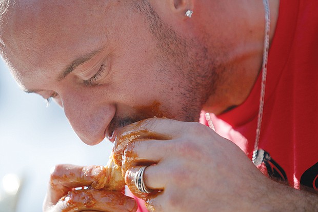 Mike Longo digs into a saucy wing at the WingFest, where he was crowned king
in the festival’s wing eating competition.