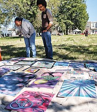 At right, Arnita Neal, left, and her son, LaJuan, check out the work of artist Henry Murray that was on display, while Riley White, below, picks up a brush and creates his own masterpiece.