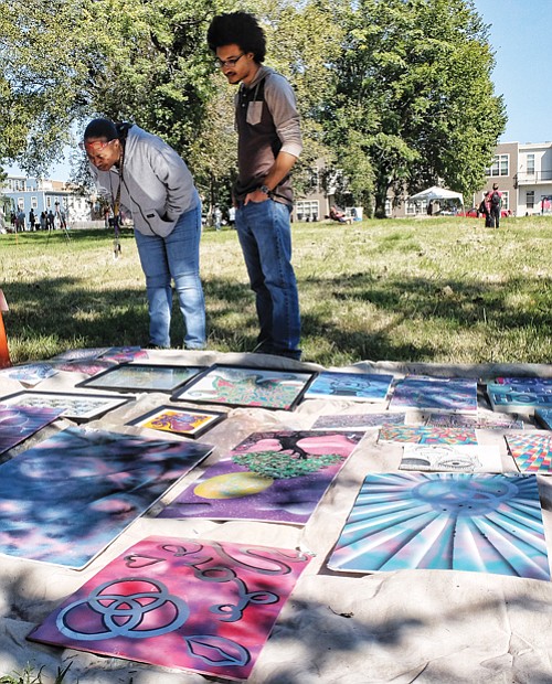 At right, Arnita Neal, left, and her son, LaJuan, check out the work of artist Henry Murray that was on display, while Riley White, below, picks up a brush and creates his own masterpiece.