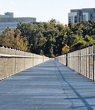 Cityscape //
It’s almost done. This is a view of the new T. Tyler Potterfield Memorial Bridge that pedestrians and cyclists can use to cross the James River. No motorized vehicles are allowed. The bridge links Brown’s Island near 5th Street in Downtown to the Manchester Climbing Wall, part of the floodwall, in South Side. It is named for the late city planner who once led the effort to create the bridge. The project took two years of planning and a year of construction. It includes improvements to the land area on the south bank to make the bridge more accessible. More than $11.5 million has been spent on the development, according to the city, including more than $9 million in city taxpayer funds and $2.5 million from a state grant. Part of the structure, now reinforced and improved, dates to 1901 and sat atop a dam that was built at the time to provide water to generate electricity at a long-defunct power plant on 12th Street. A few years ago, the old power plant was transformed into apartments.